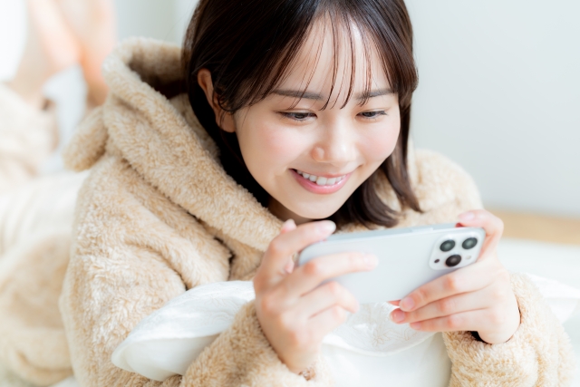 スマホを見て安心する女性